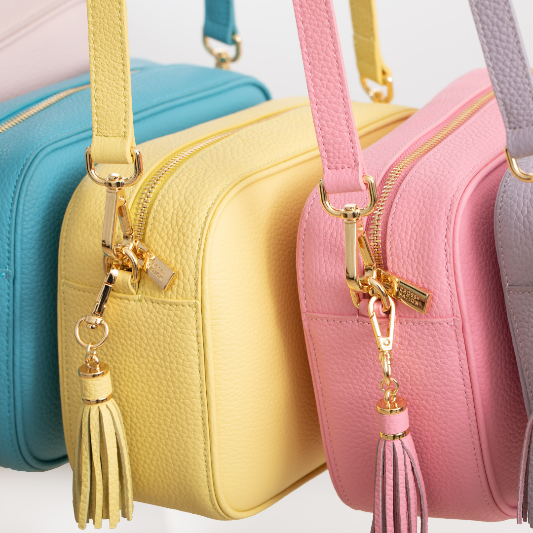 Colorful handbags with tassel charms on a white background