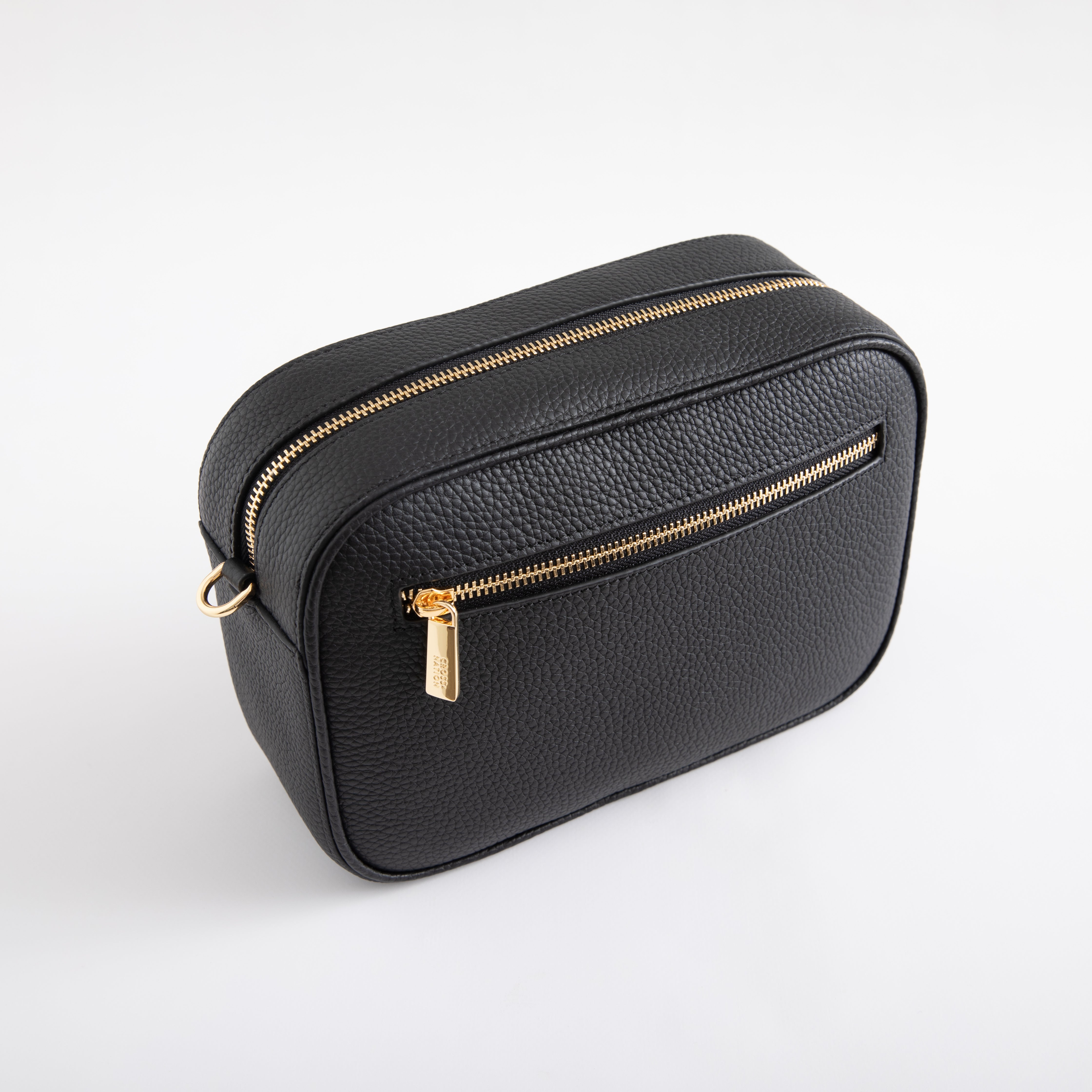 Black leather bag with gold zippers on a white background
