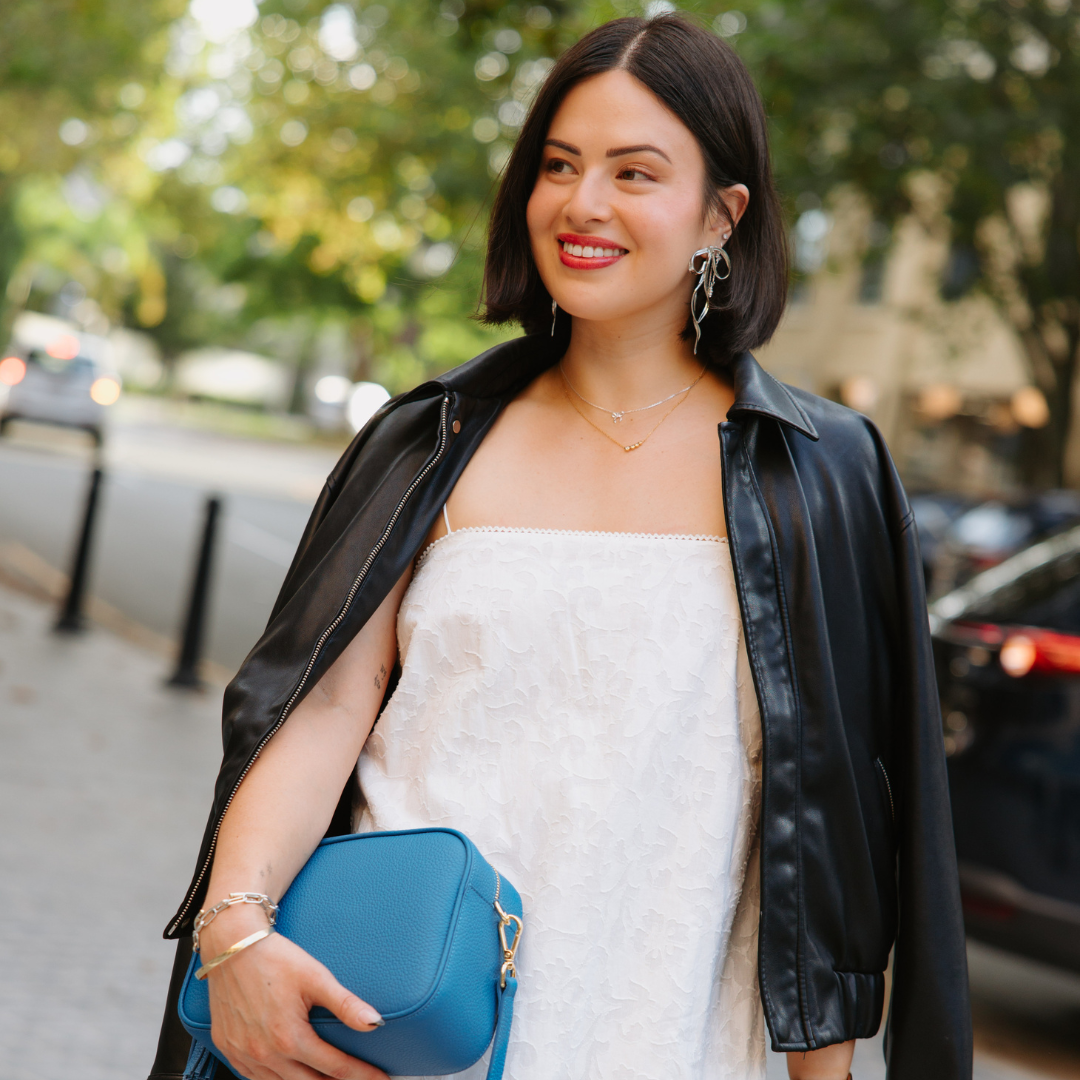 Woman holding a blue handbag on a city street