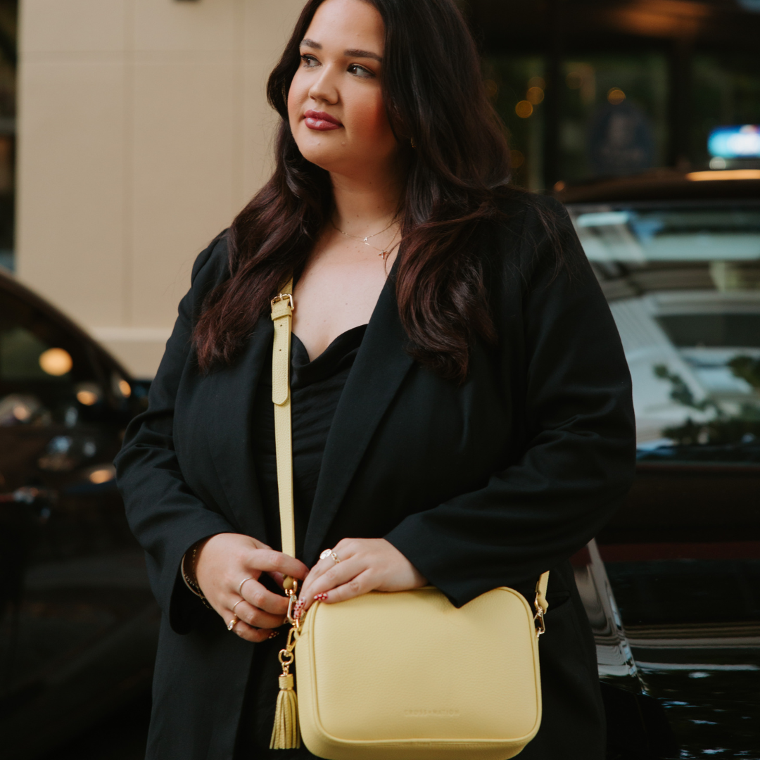 Woman holding a yellow handbag in an urban setting