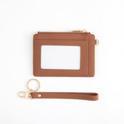 Brown leather cardholder with wrist strap on a white background